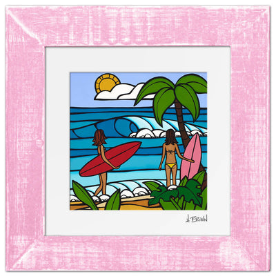 Pink framed matted art print by Hawaii artist Heather Brown featuring two female Hawaii surfers with red and pink surfboards looking at waves on the beach
