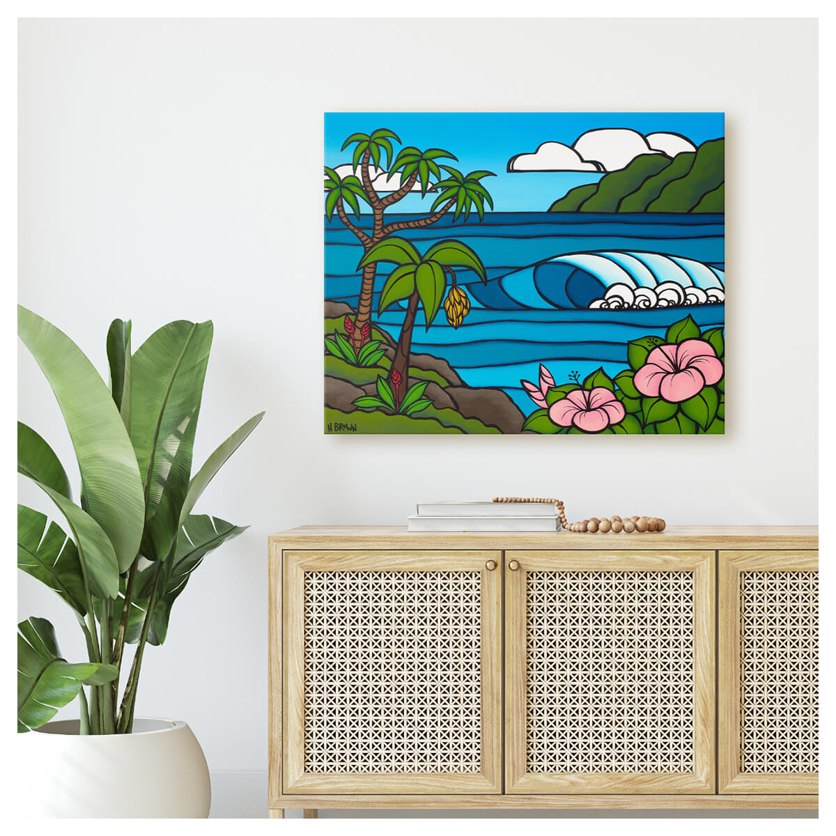 Large tropical canvas wall art by Kauai artist Heather Brown, featuring a serene Hawaii seascape with a cresting wave, framed by pink hibiscus flowers and a banana tree with green mountains in the distance.