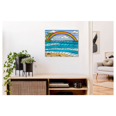 A metal art print that features a rainbow framing an iconic view of a Hawaii beach by Hawaii surf artist Heather Brown