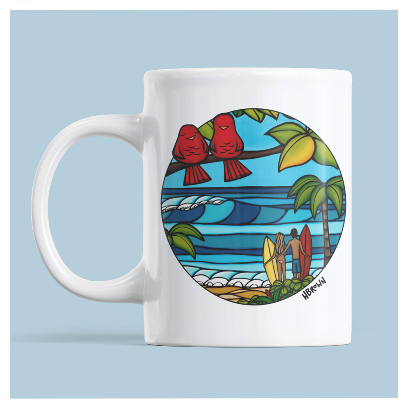 A white ceramic mug featuring two red love birds on a branch framing a beautiful tropical view with a surf couple by Hawaii surf artist Heather Brown
