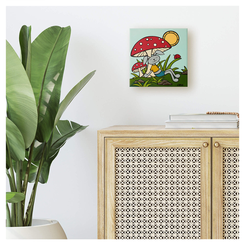 Vibrant red mushroom with a gray rabbit sleeping beneath by Hawaii surf artist Heather Brown