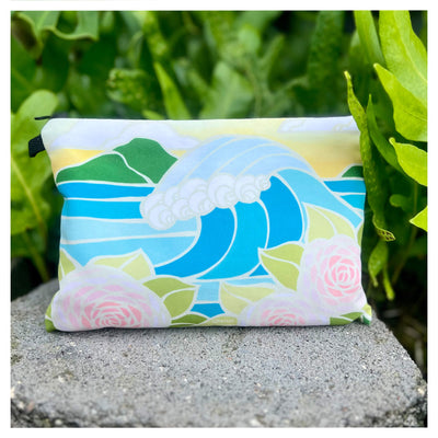 a beach clutch featuring an epic crashing framed by vibrant pink roses by Hawaii surf artist Heather Brown