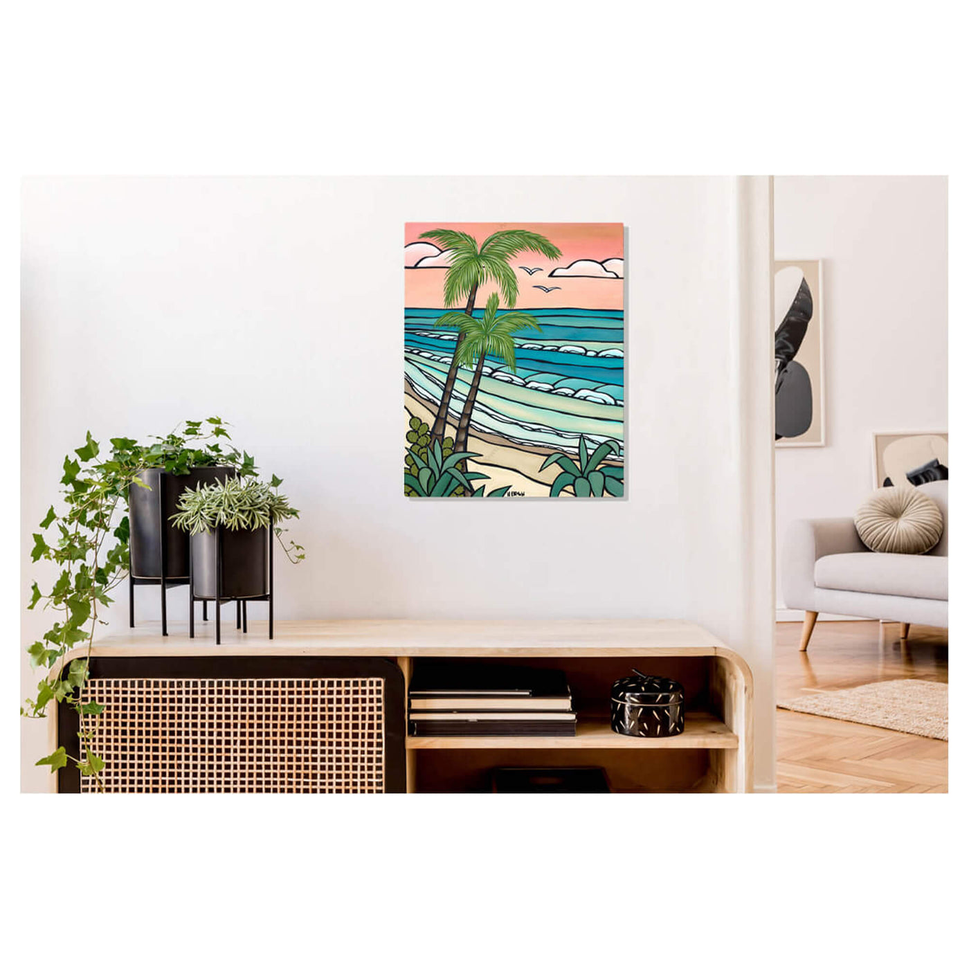 A metal art print featuring rolling waves meeting a secluded beach against a pink-hued by Hawaii surf artist Heather Brown